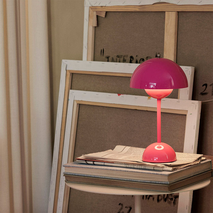 Tangy Pink &Tradition VP9 Flowerpot Portable Table Lamp on stack of newspapers in design studio.