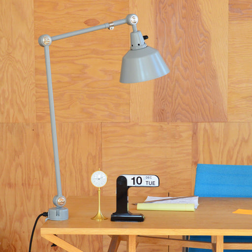 Midgard Modular Clamp Lamp 552 positioned on a home office desk, serving as a task lamp for focused work.