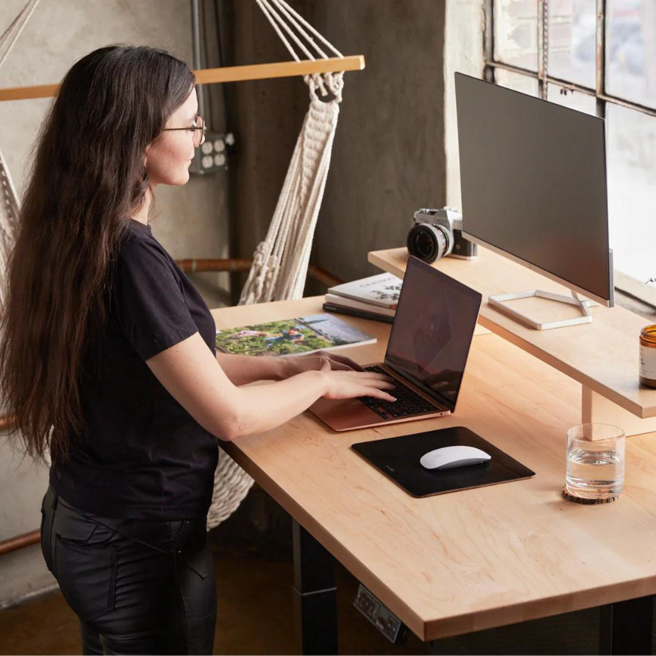 burotic standing desk with young women using her laptop.