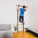 Man engaging in a pull-up exercise on a black BenchK wall bar installed in a home setting