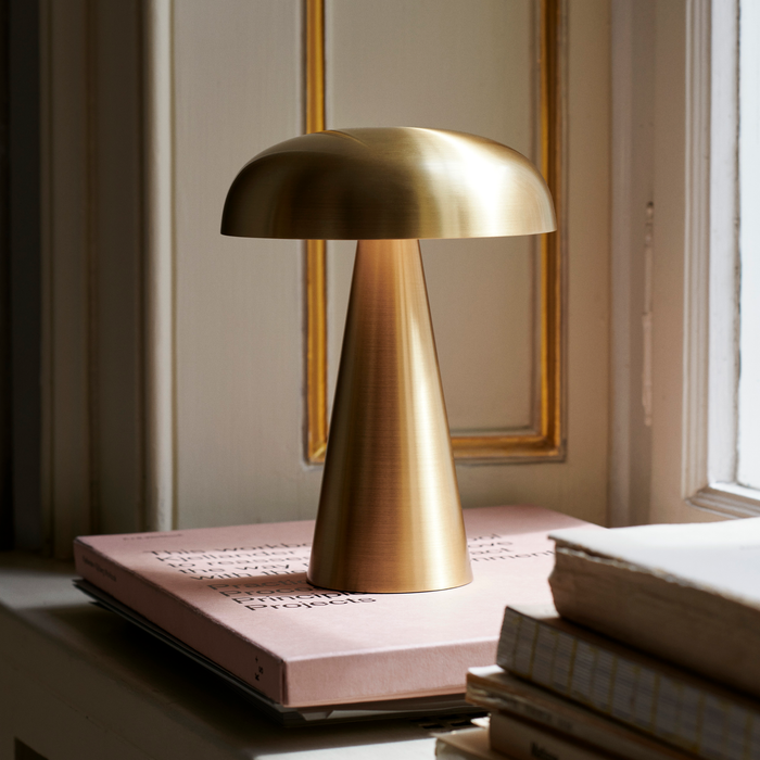 Brass &Tradition SC53 Como Portable Lamp on stack of books beside window.