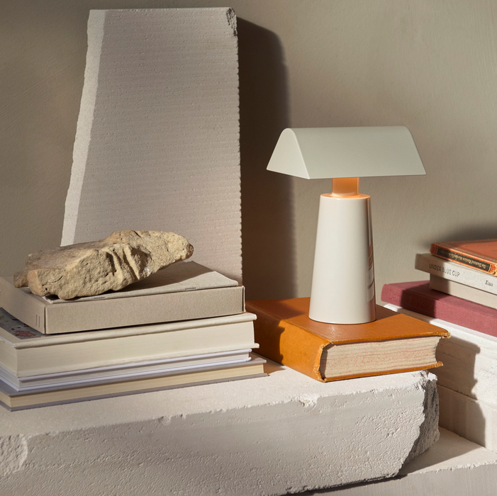 Silk Grey &Tradition MF1 Caret Portable Table Lamp Illuminating a Book with Surrounding Books, Highlighting its Use as a Reading Lamp