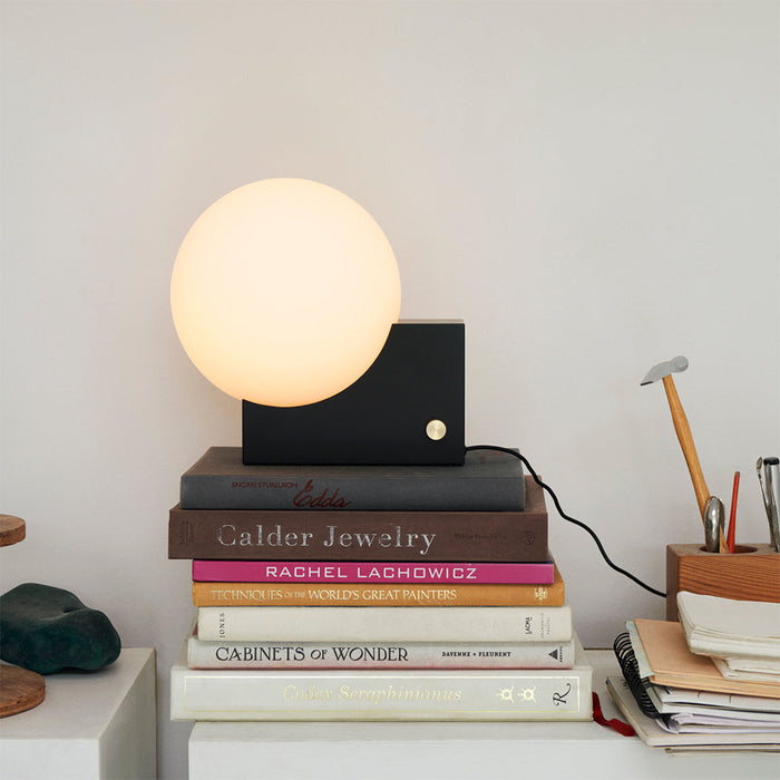 Black &Tradition SHY1 Journey Table Lamp on stack of books in office.