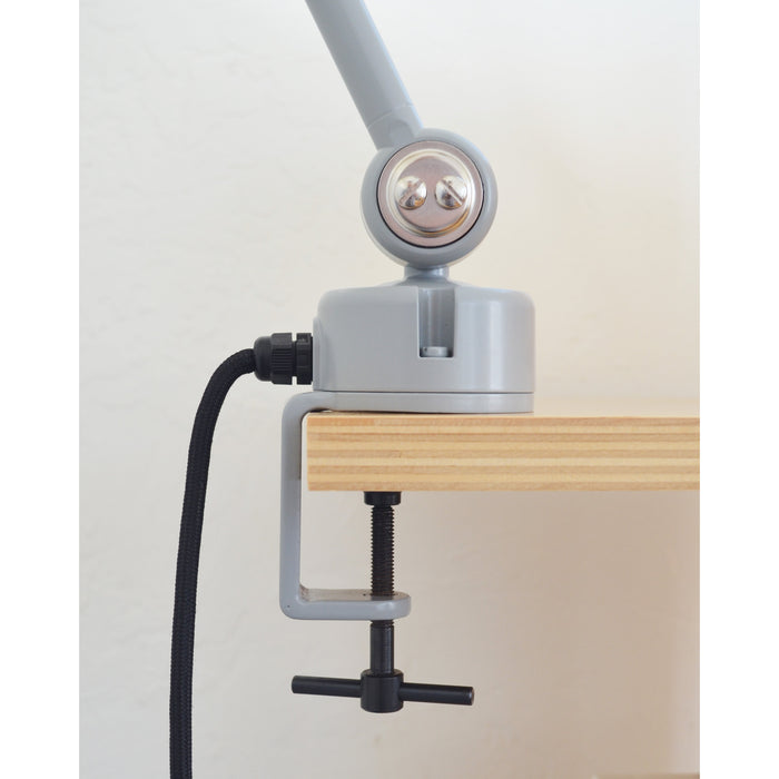 Close-up view of the clamp mechanism of the Midgard Modular Clamp Lamp 552 securely attached to a desk surface.